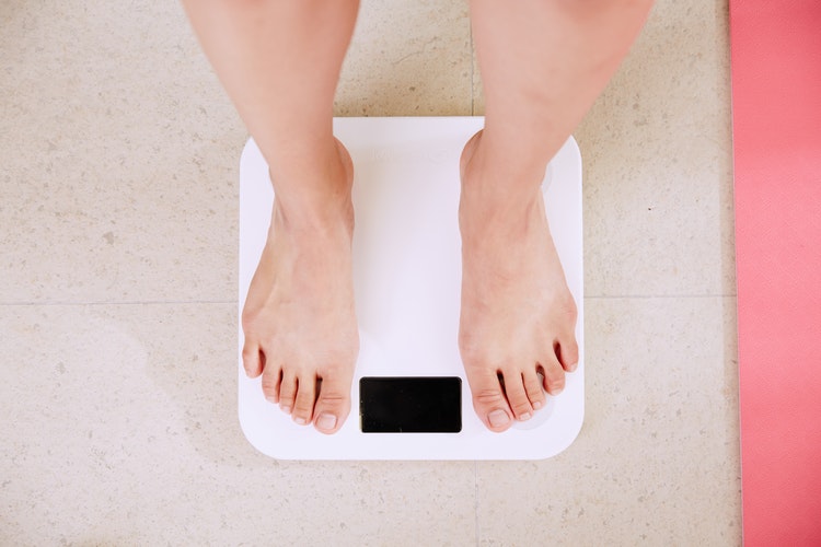 Une femme sur une balance pour mesurer son poids