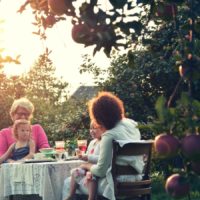 Une famille prenant le petit dejeuner dans le jardin
